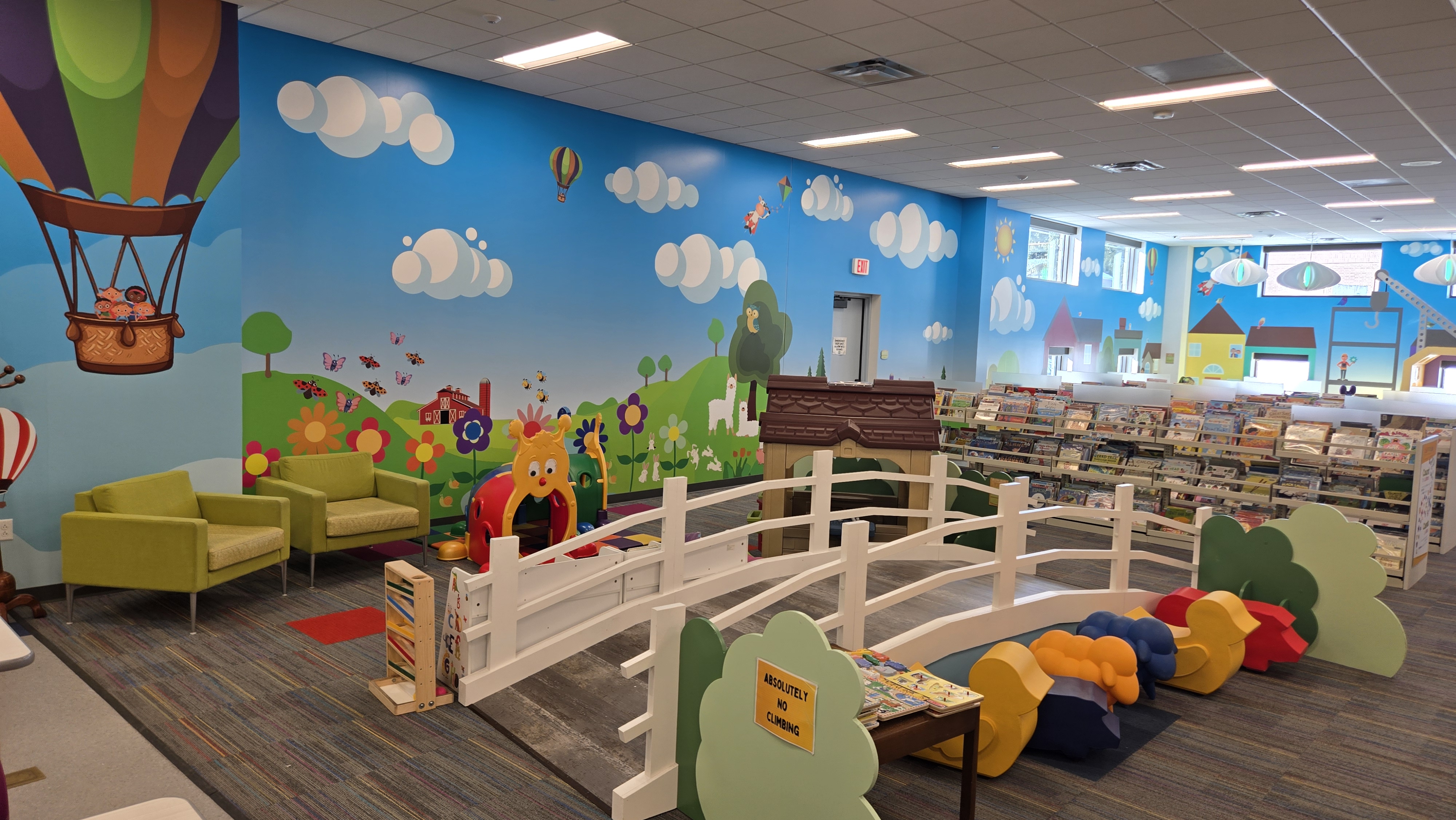 Colorful wallpaper with clouds and a nature scene with a hot air balloon. White wooden bridge is in center of the shot with comfortable chairs for seating in the background.