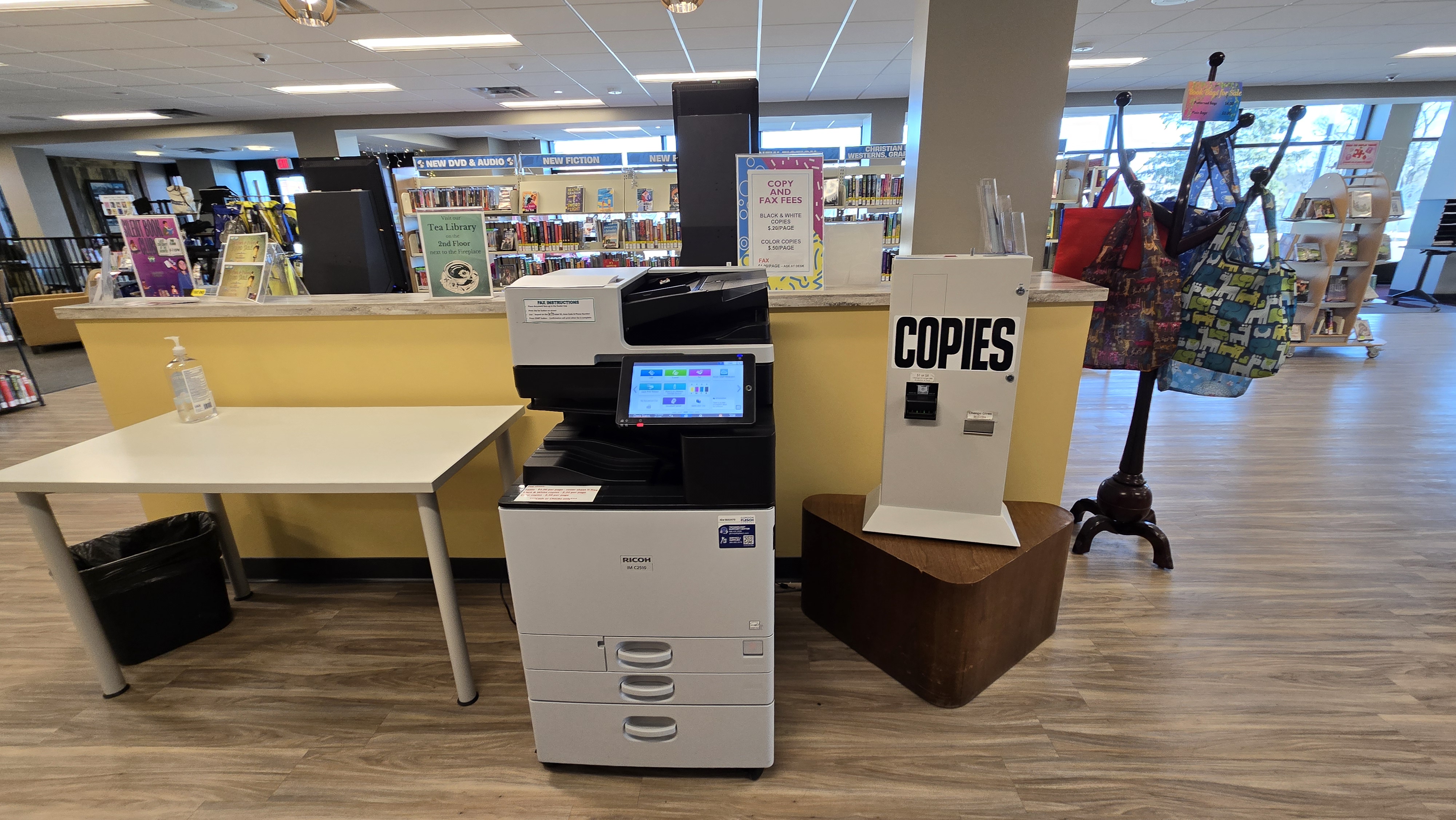 Copy machine in the center, with a table to the left and a coin/bill handling machine to the right.